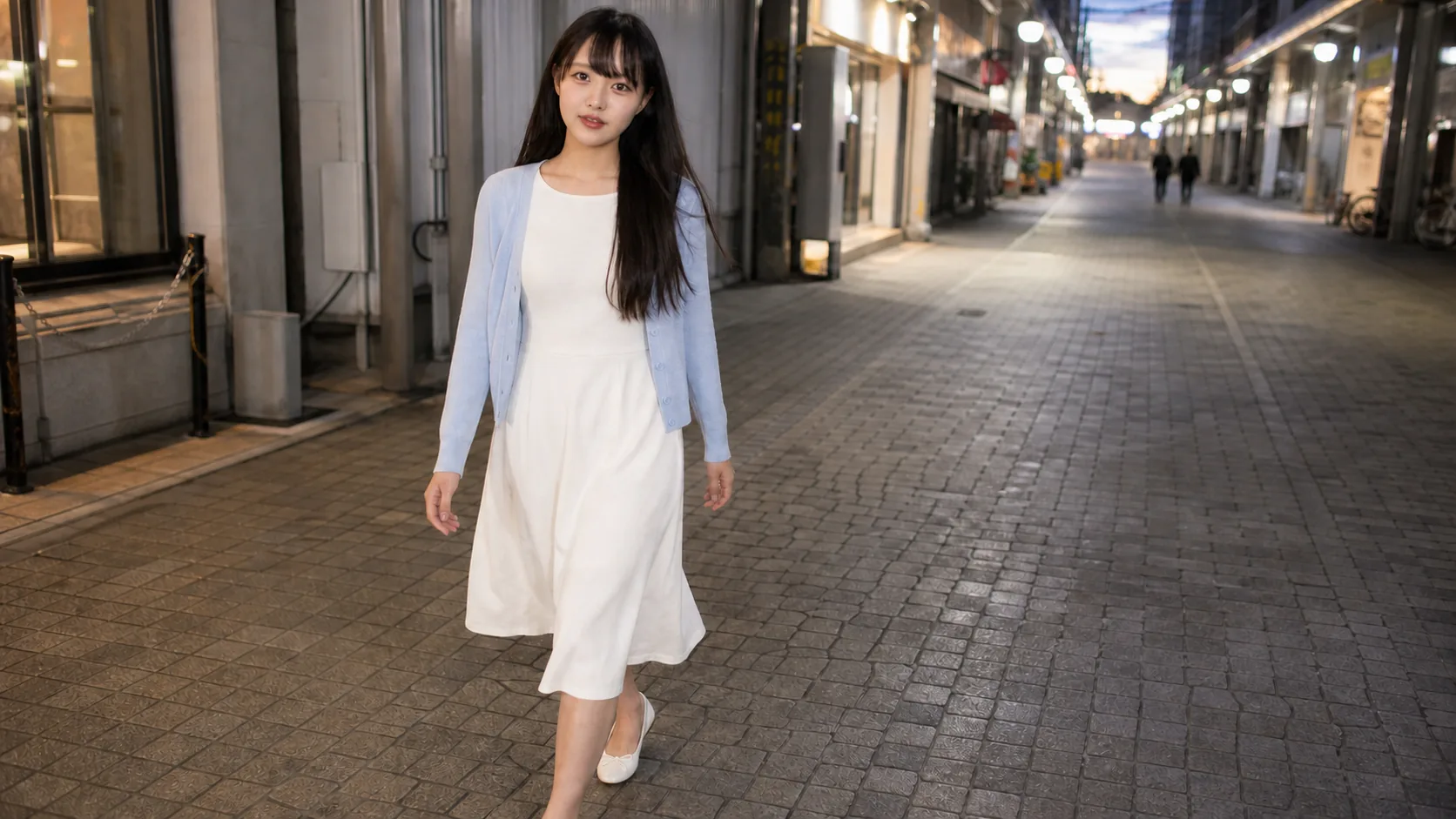 夕方の商店街で、白いワンピースと淡い青のカーディガンを着てこちらへ歩く人物